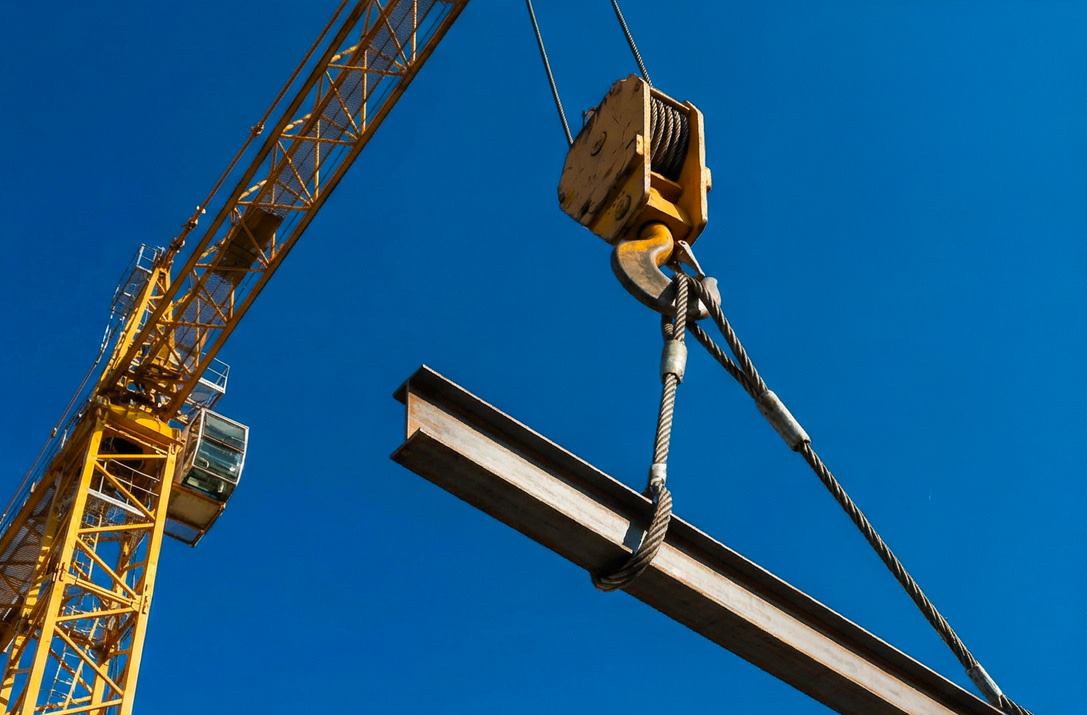 Tower crane lifting a steel beam